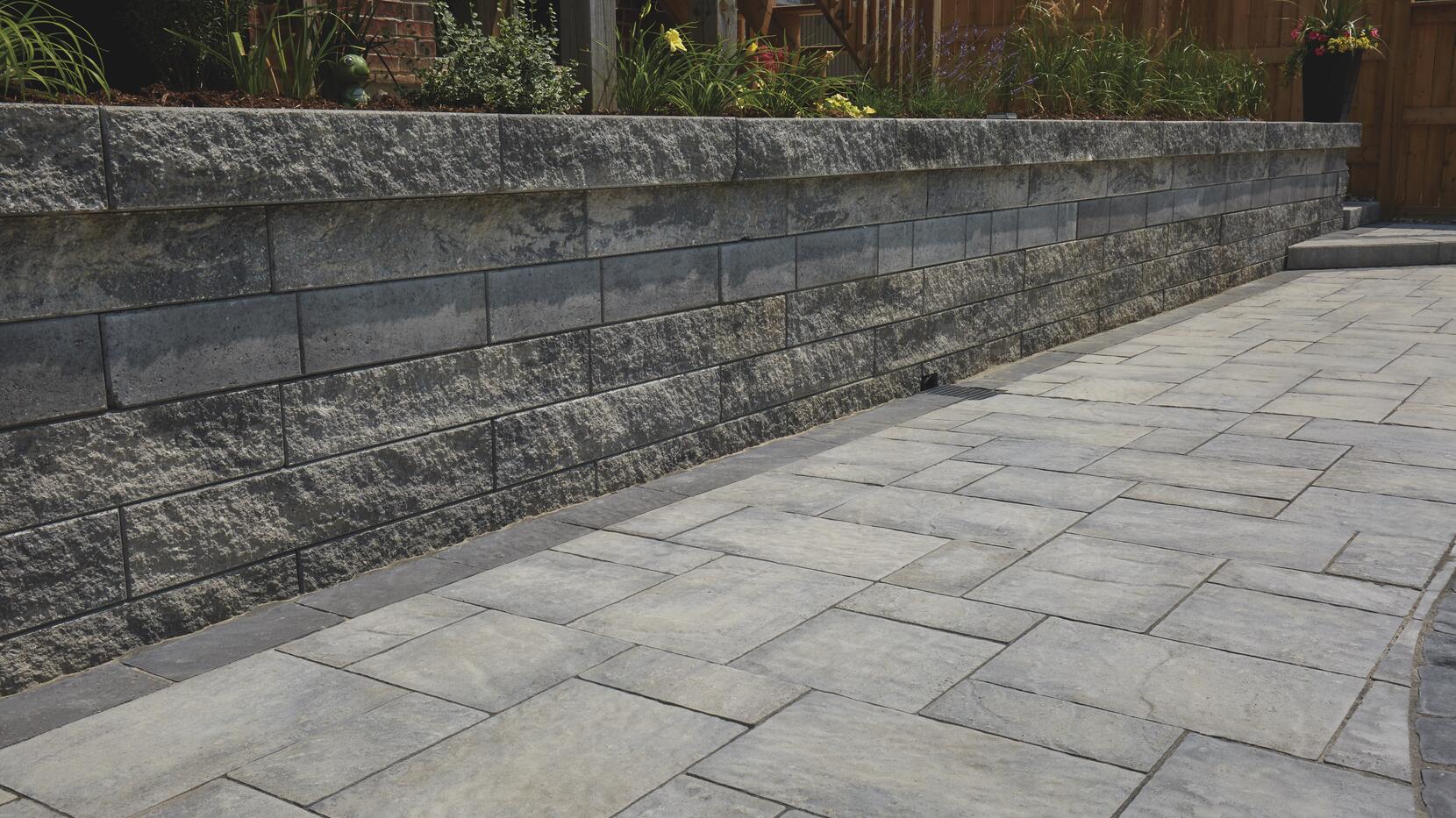 Wall: Proterra Greyfield, Split with Greyfield, Smooth accent band Pavers: Villanova, Champagne with Onyx Border